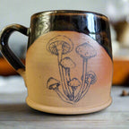 Ceramic mug with mushroom design on a plain background