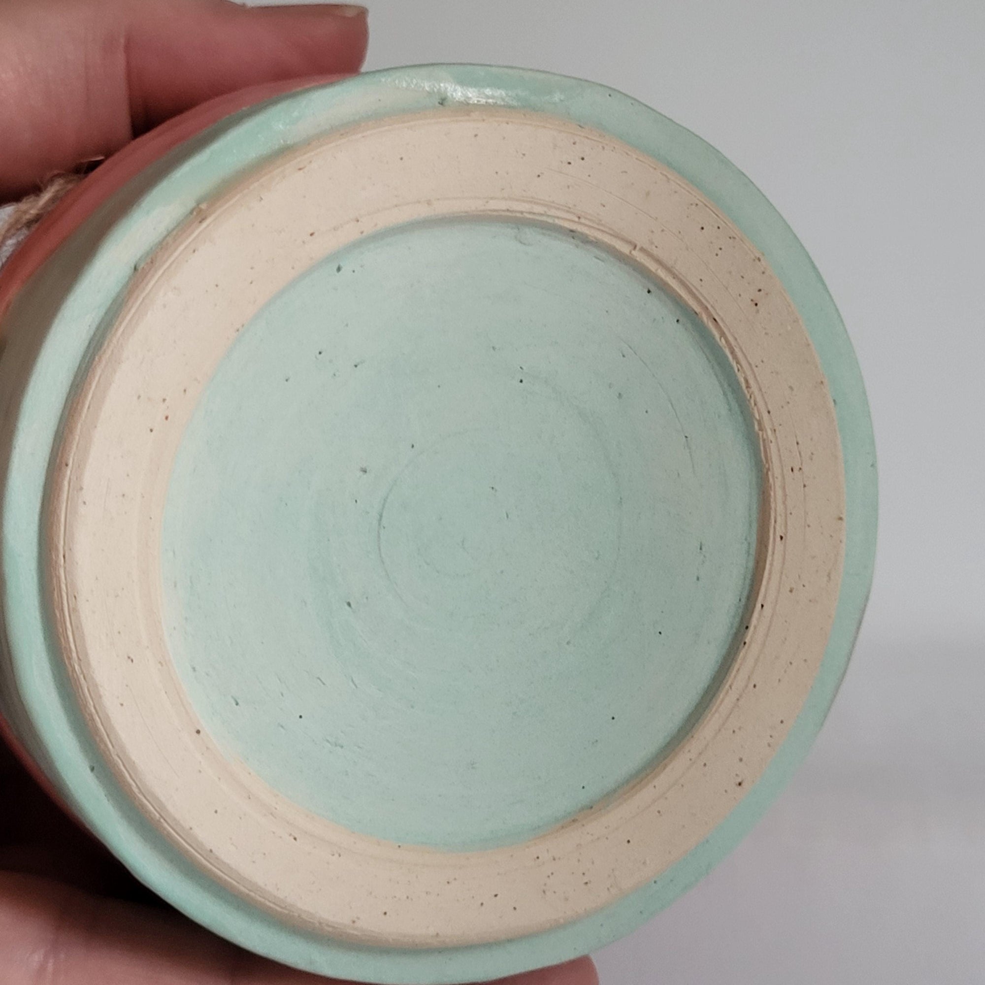 Tea light candle holder with star cutouts and pink and aqua glaze