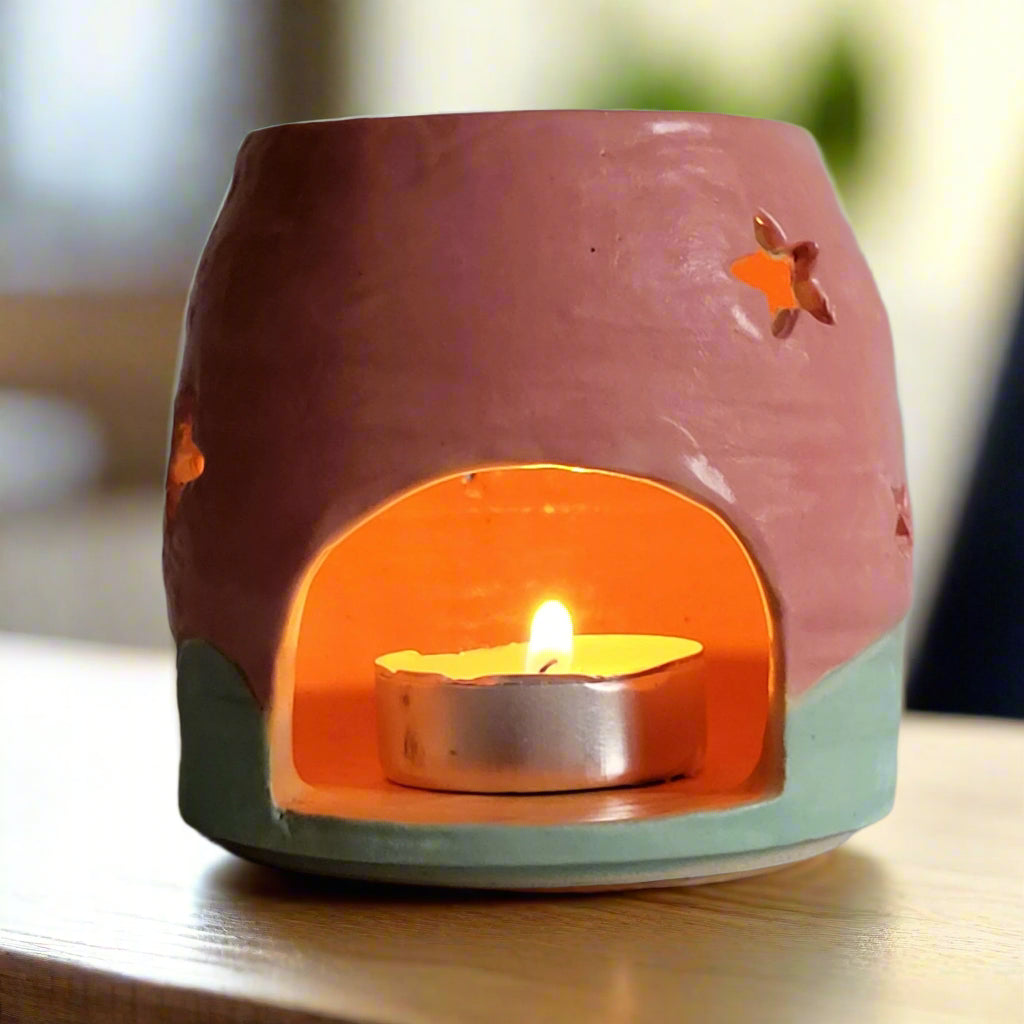Ceramic candle holder with a lit tealight candle on a neutral background