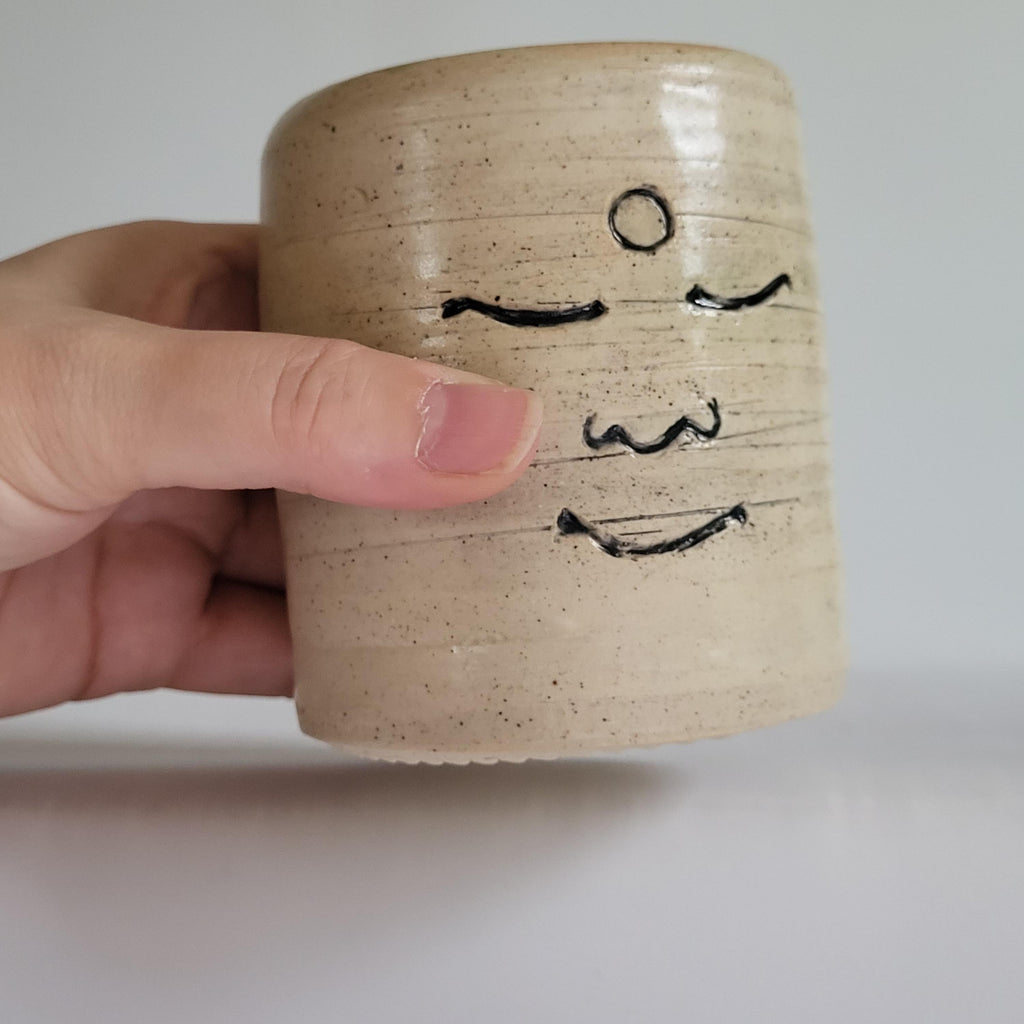 Tea Cup, Buddha face, serene happy face carved design.
