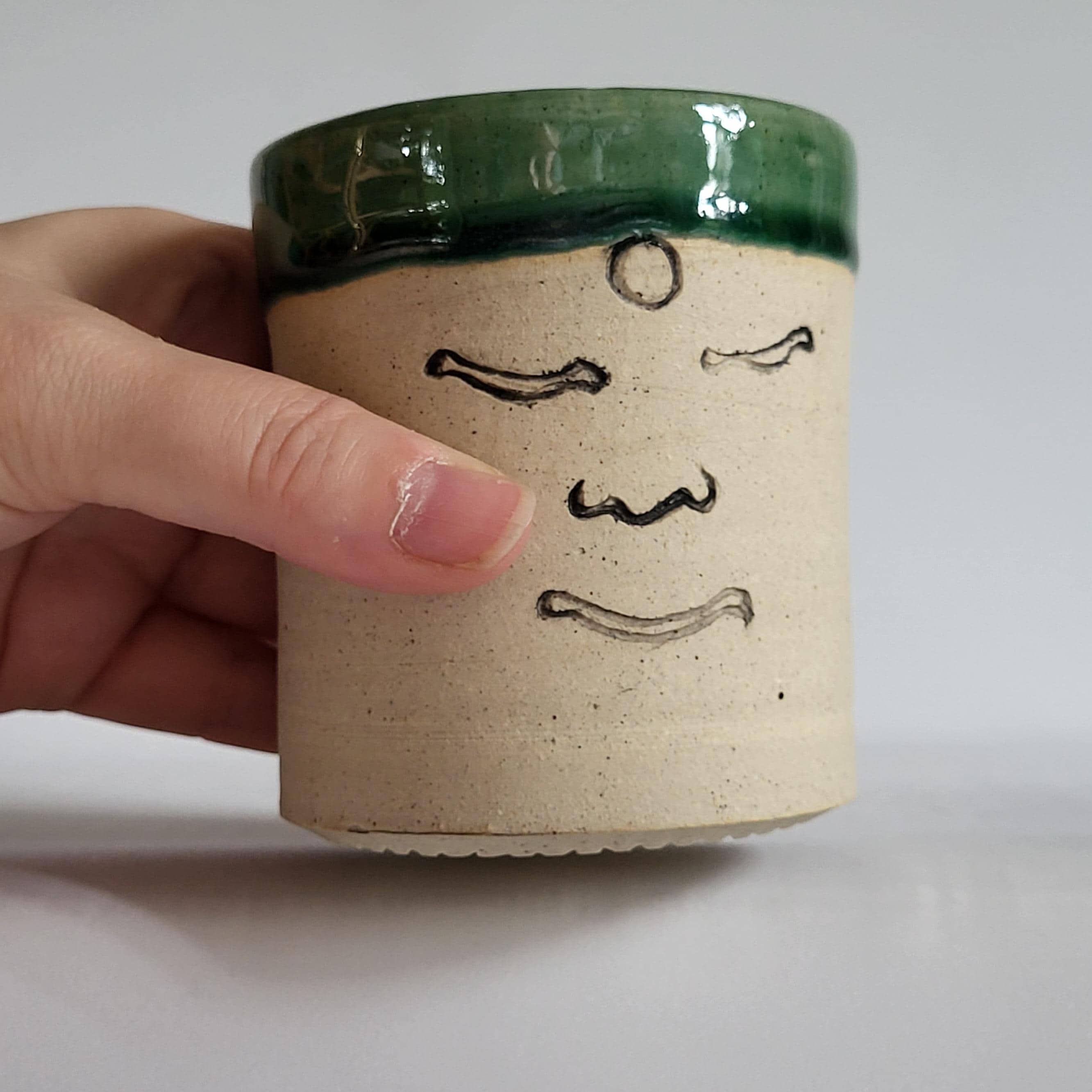 Tea Cup, Buddha face tea cup, serene happy face carved design. green glaze hat